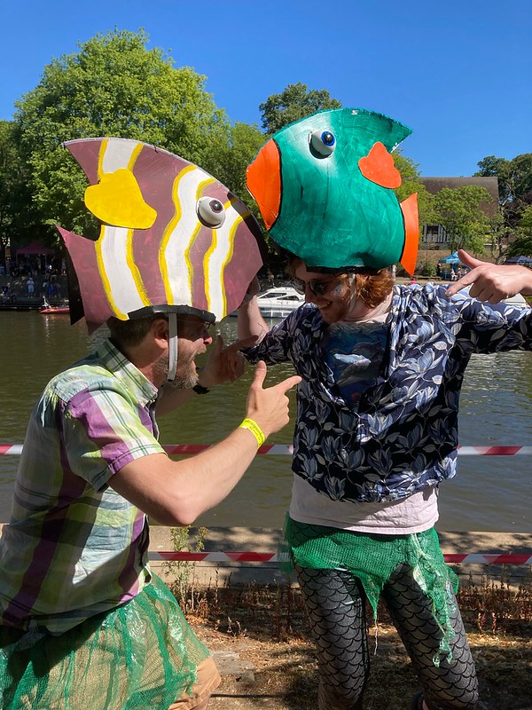 Two AAM volunteers pose with white and purple and green and orange fishy hats