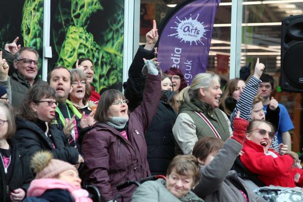 AAM's projects sign and sign together at a busking event at Asda, Monks Cross