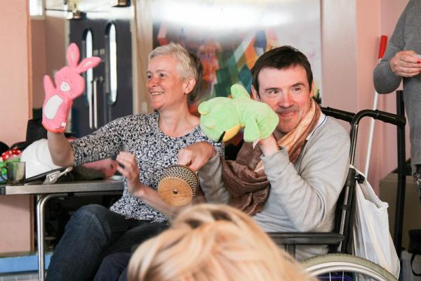Participant and Support Worker playing with hand puppets