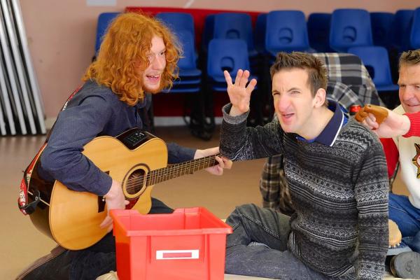 Participant interacting and vocalising with an AAM artist who's playing a guitar