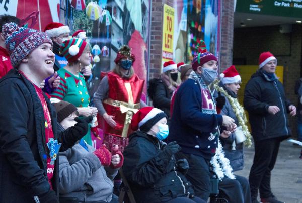Hand & Voices and IMPs Choirs sing together wearing Christmas hats
