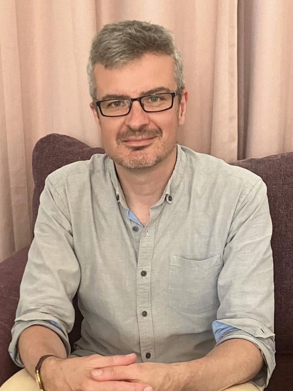 David Martin sits in a chair with his hands overlocking one another 