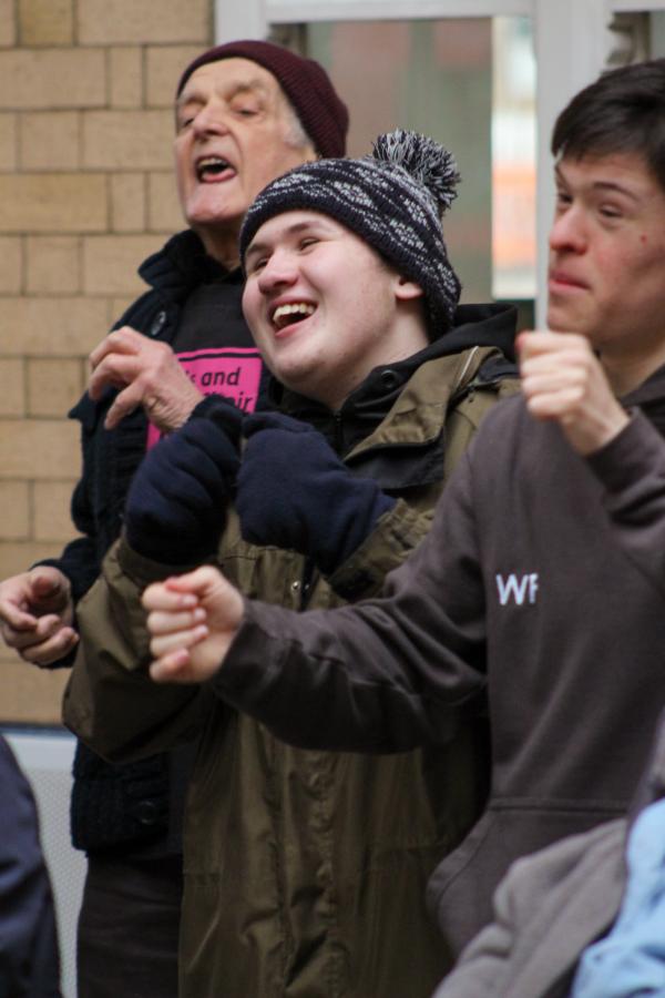 AAM Buskers smile as they sing in bobbly hats and coats at York Station