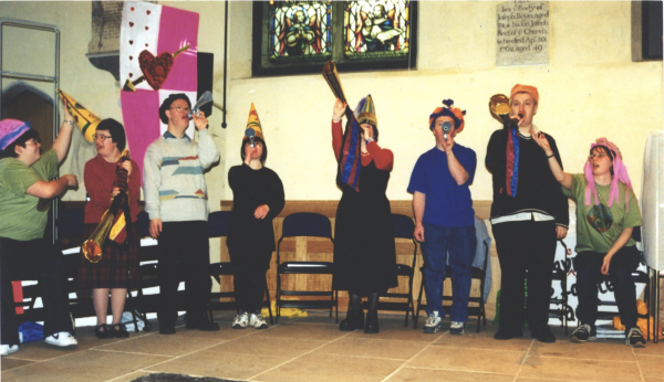 Hand & Voices wear Elizabethan style hats as they play horns in rehearsals