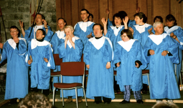 Hands & Voices performing Go Down Moses in blue choir gowns